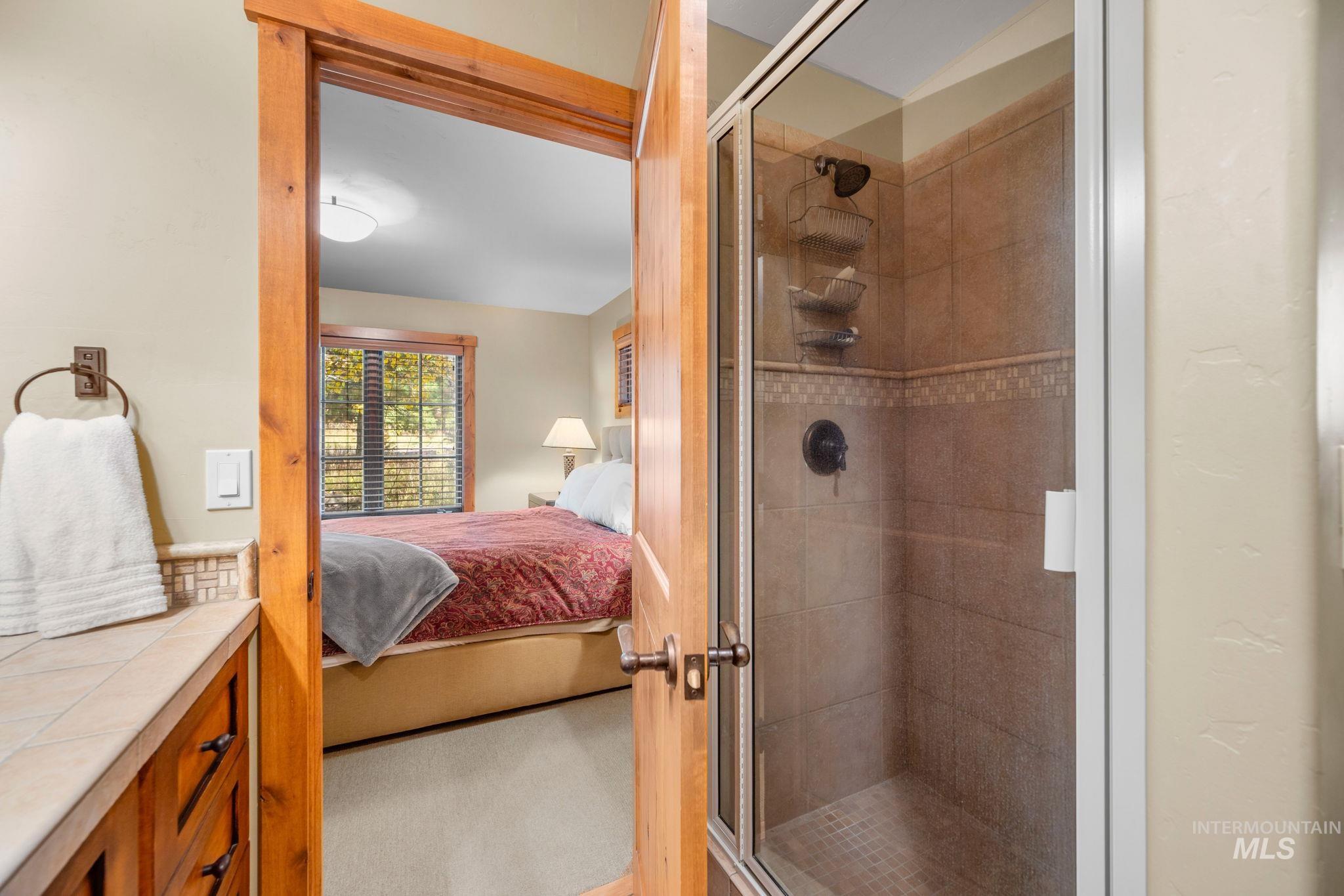 Ensuite bathroom featuring a shower stall and vanity