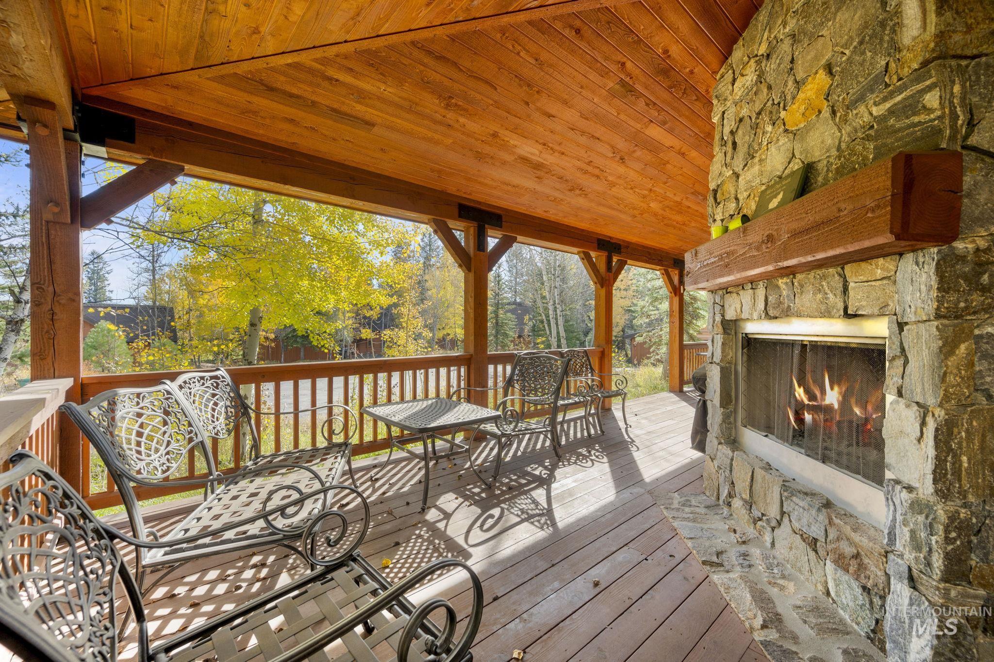 Wooden terrace with an outdoor stone fireplace