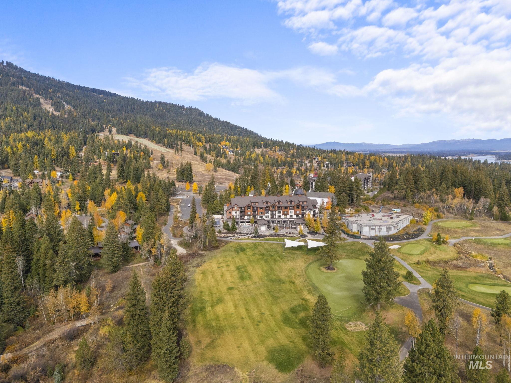 Aerial view of property's location featuring mountains and a local golf course