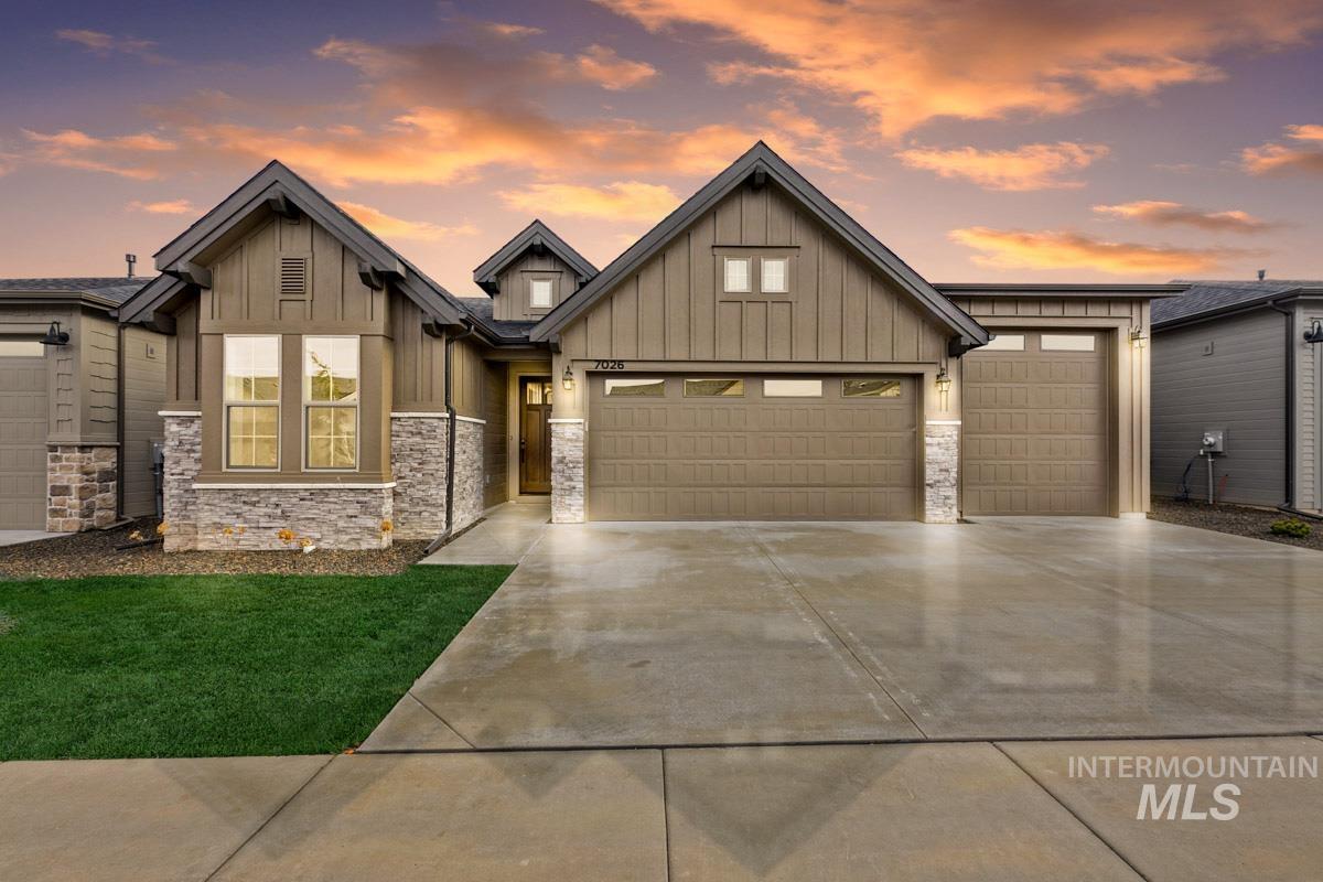 Craftsman-style home with board and batten siding, driveway, and a garage