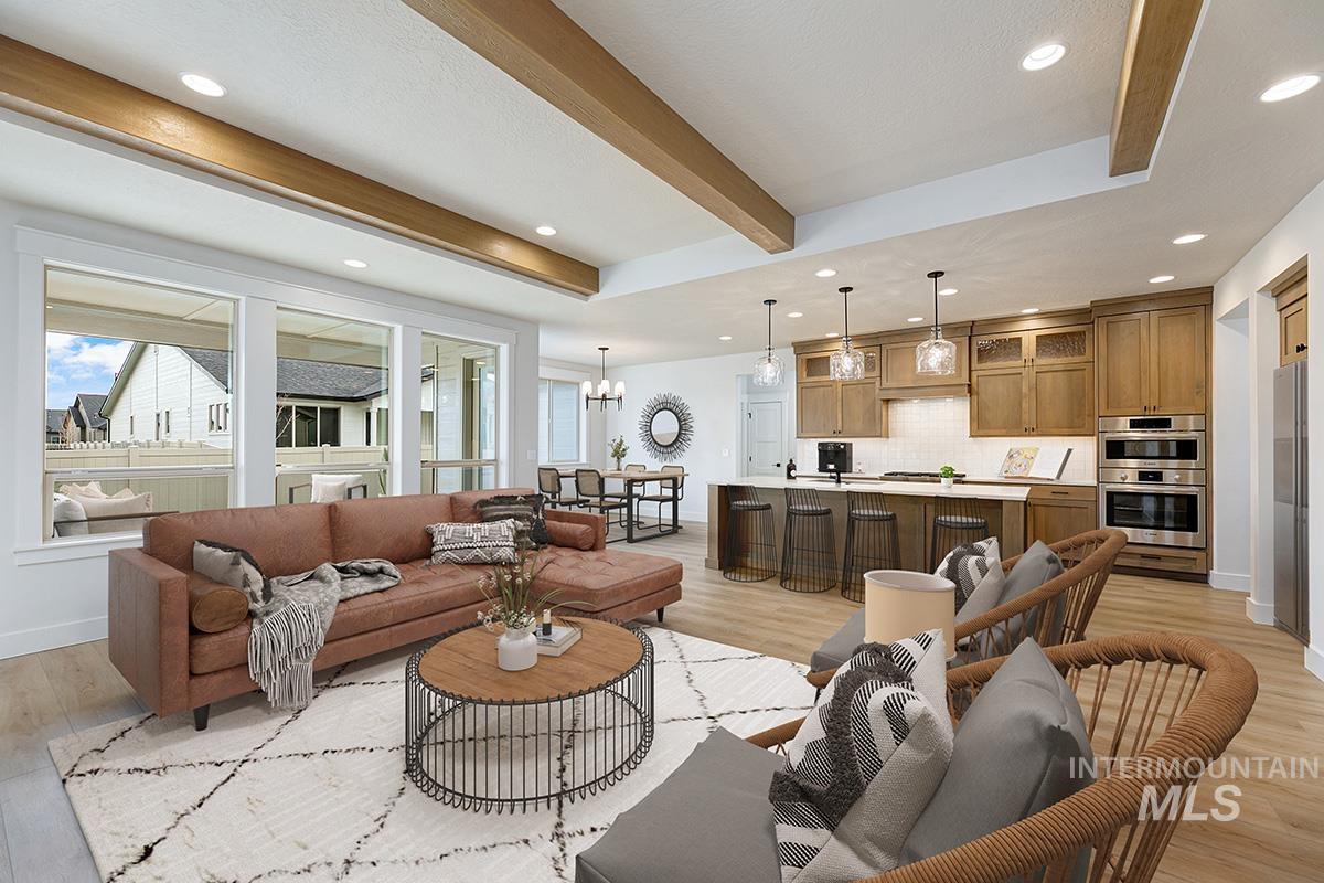 Living area with a chandelier, beam ceiling, light wood-style floors, plenty of natural light, and recessed lighting