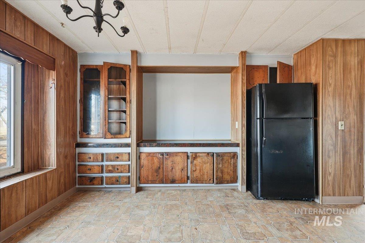 Unfurnished living room featuring wood walls