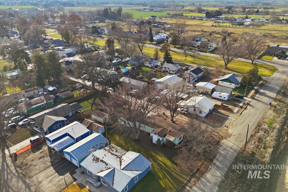 Aerial view of property and surrounding area with nearby suburban area