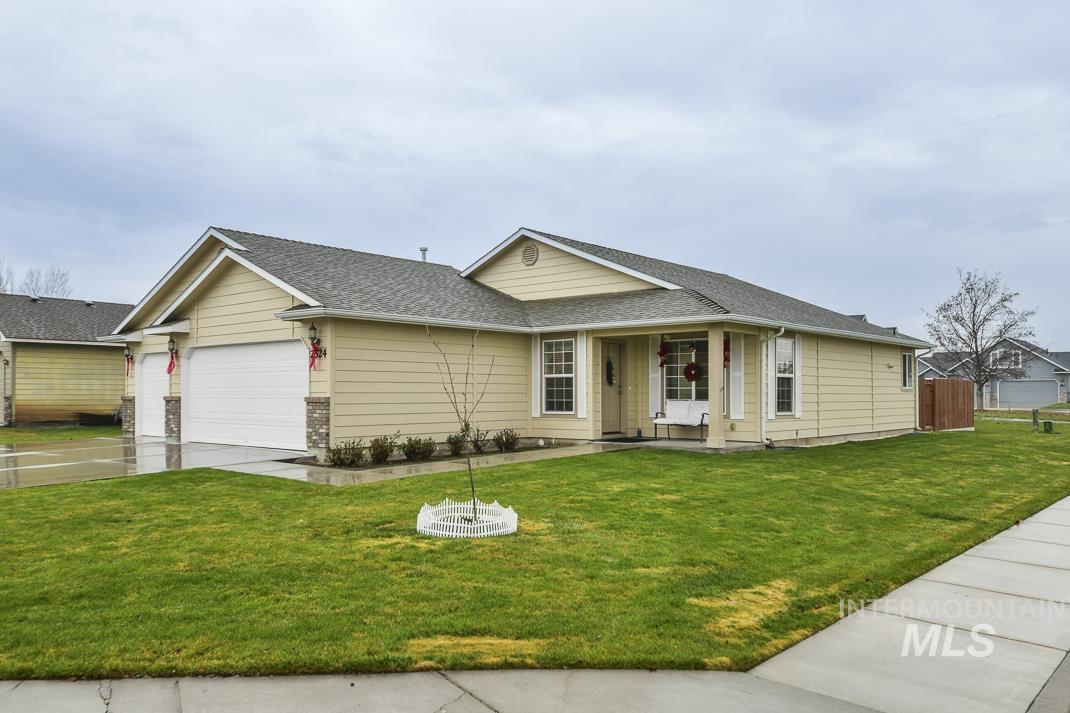 Single story home featuring a shingled roof, an attached garage, concrete driveway, and a porch