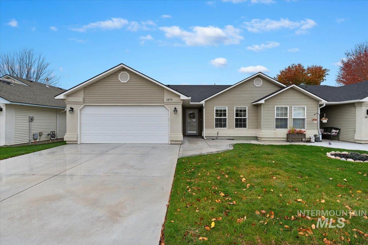 Ranch-style home with a front lawn, driveway, and a garage