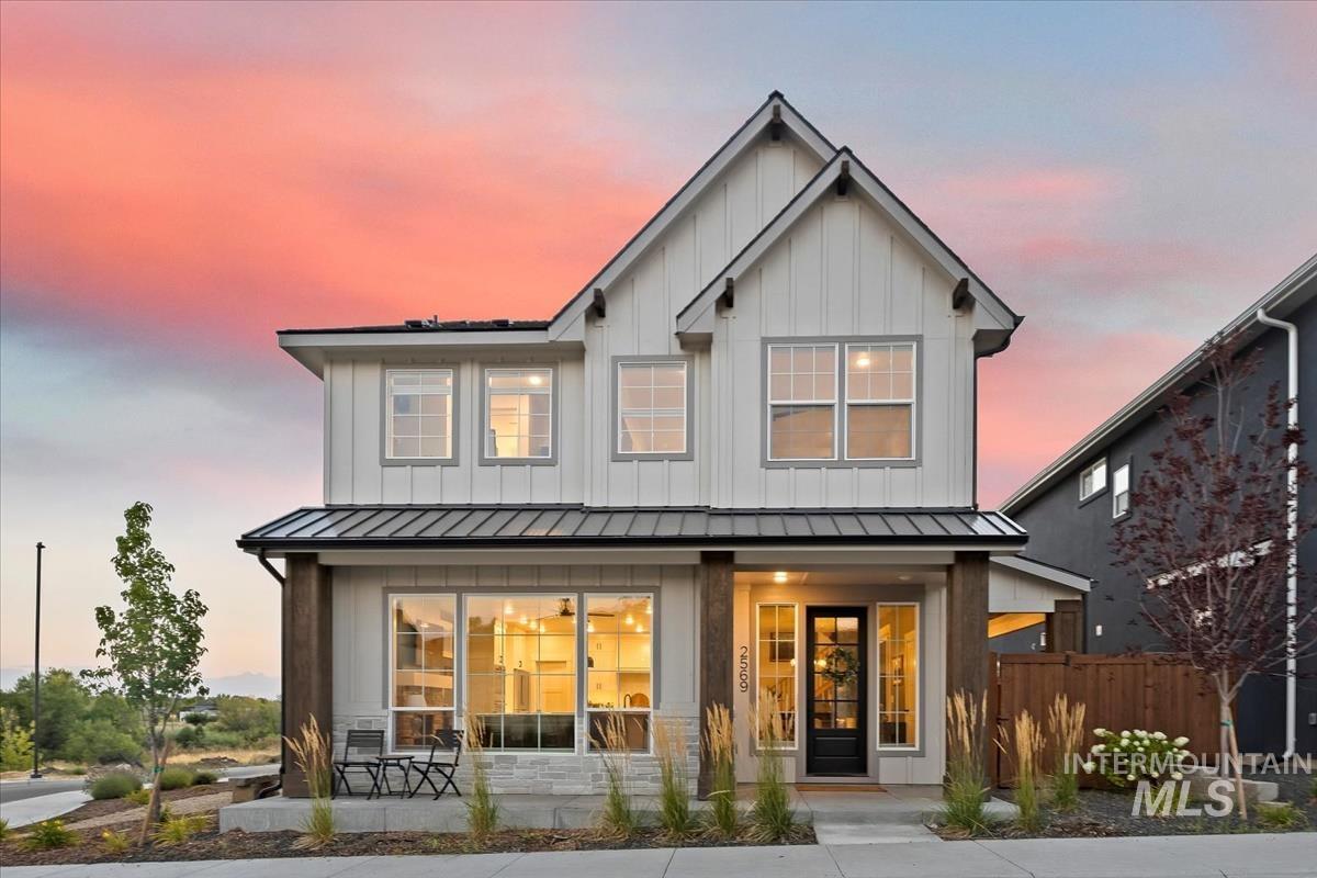 Back of house with a standing seam roof, a metal roof, board and batten siding, and a porch