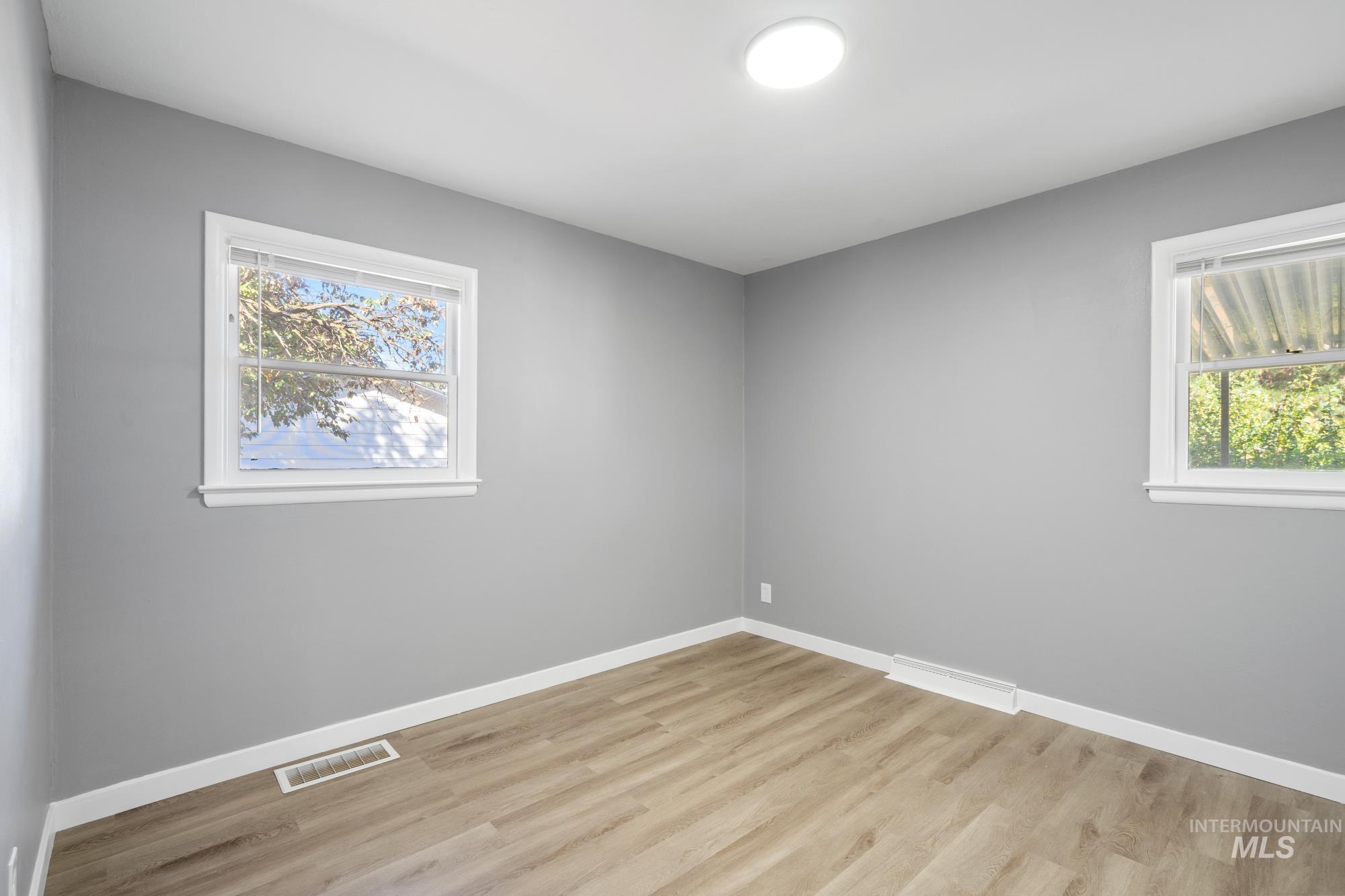 Spare room featuring light wood-style flooring and healthy amount of natural light
