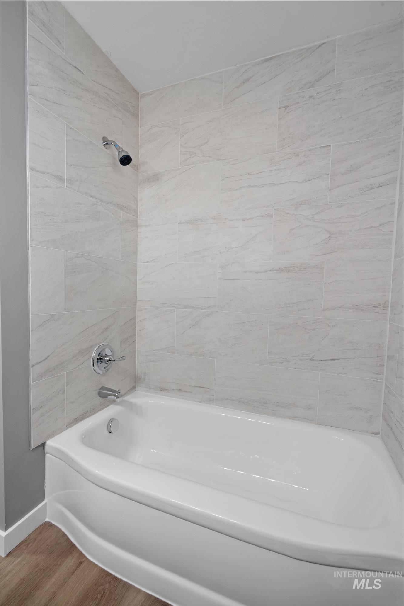 Full bath featuring shower / bath combination and wood finished floors