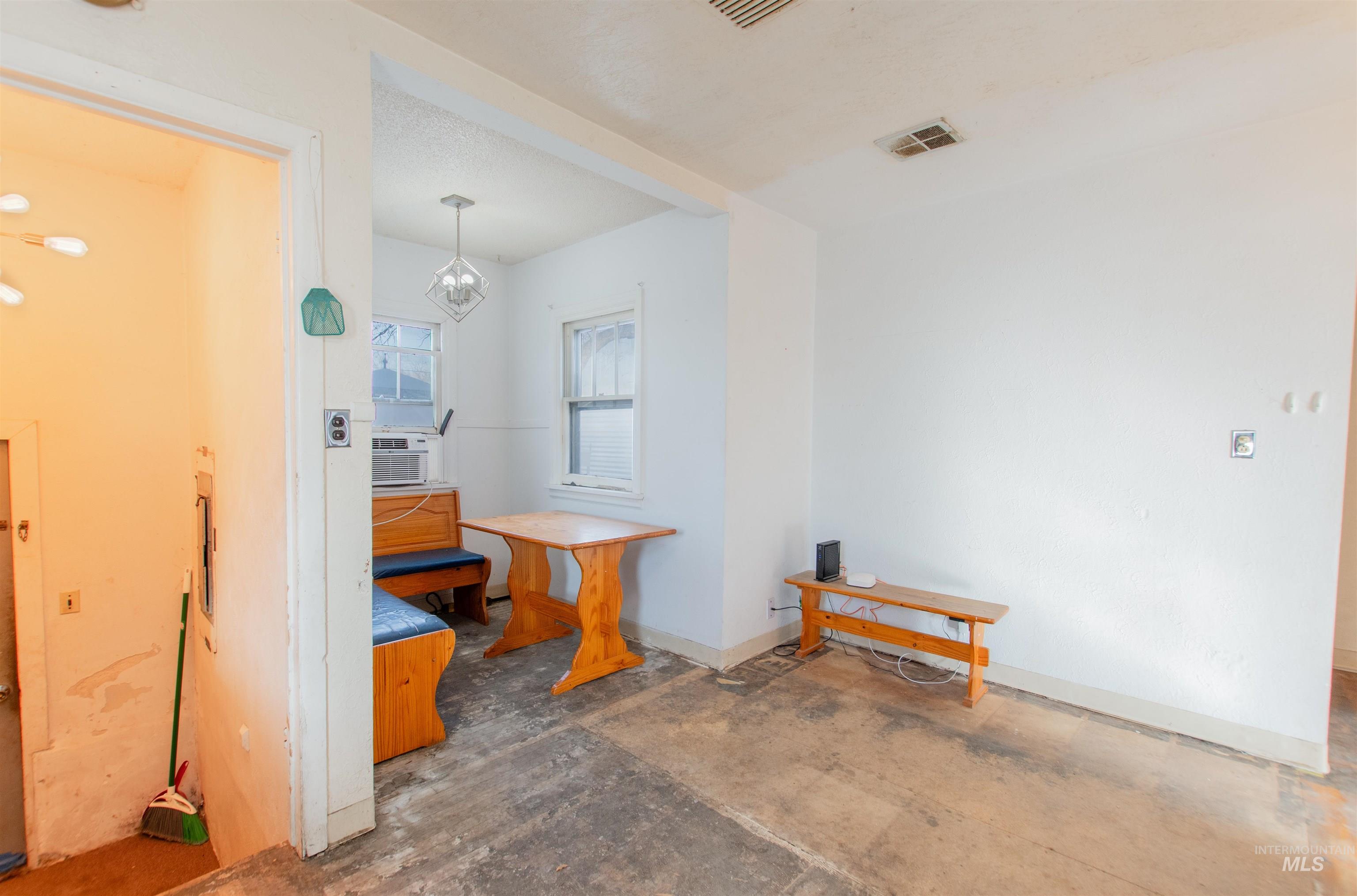 Misc room with a chandelier and concrete floors