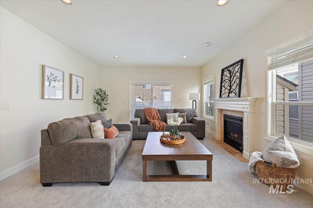 Living area featuring a fireplace, light colored carpet, and recessed lighting