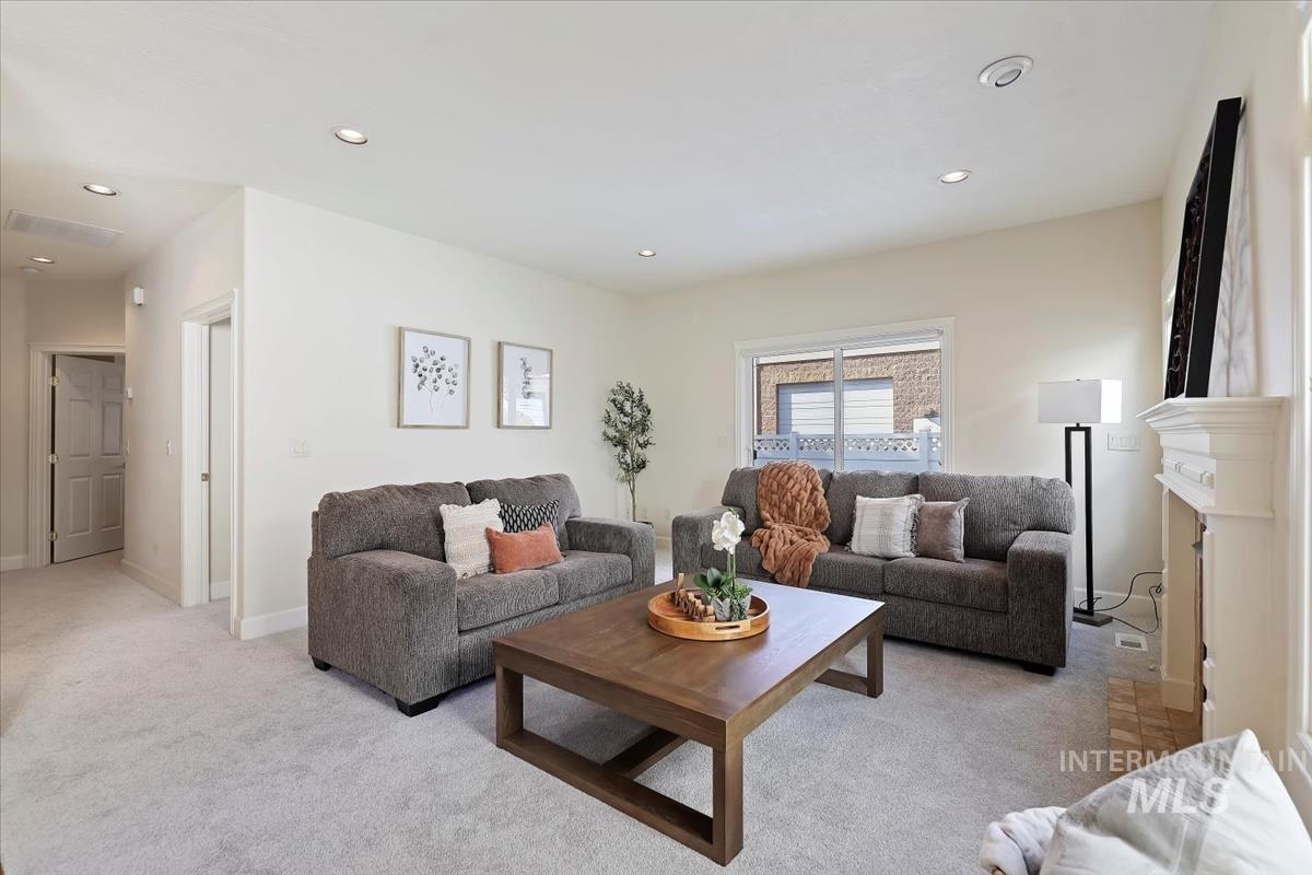 Living room featuring light colored carpet, recessed lighting, and a fireplace