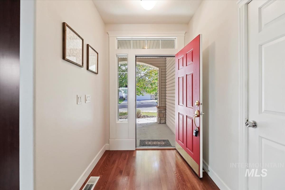 Foyer featuring dark wood-style floors and baseboards