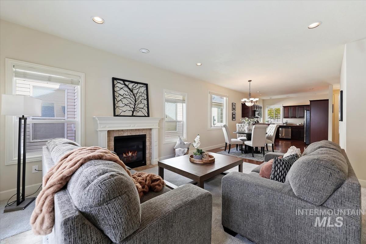 Living area with a tiled fireplace, recessed lighting, and a chandelier
