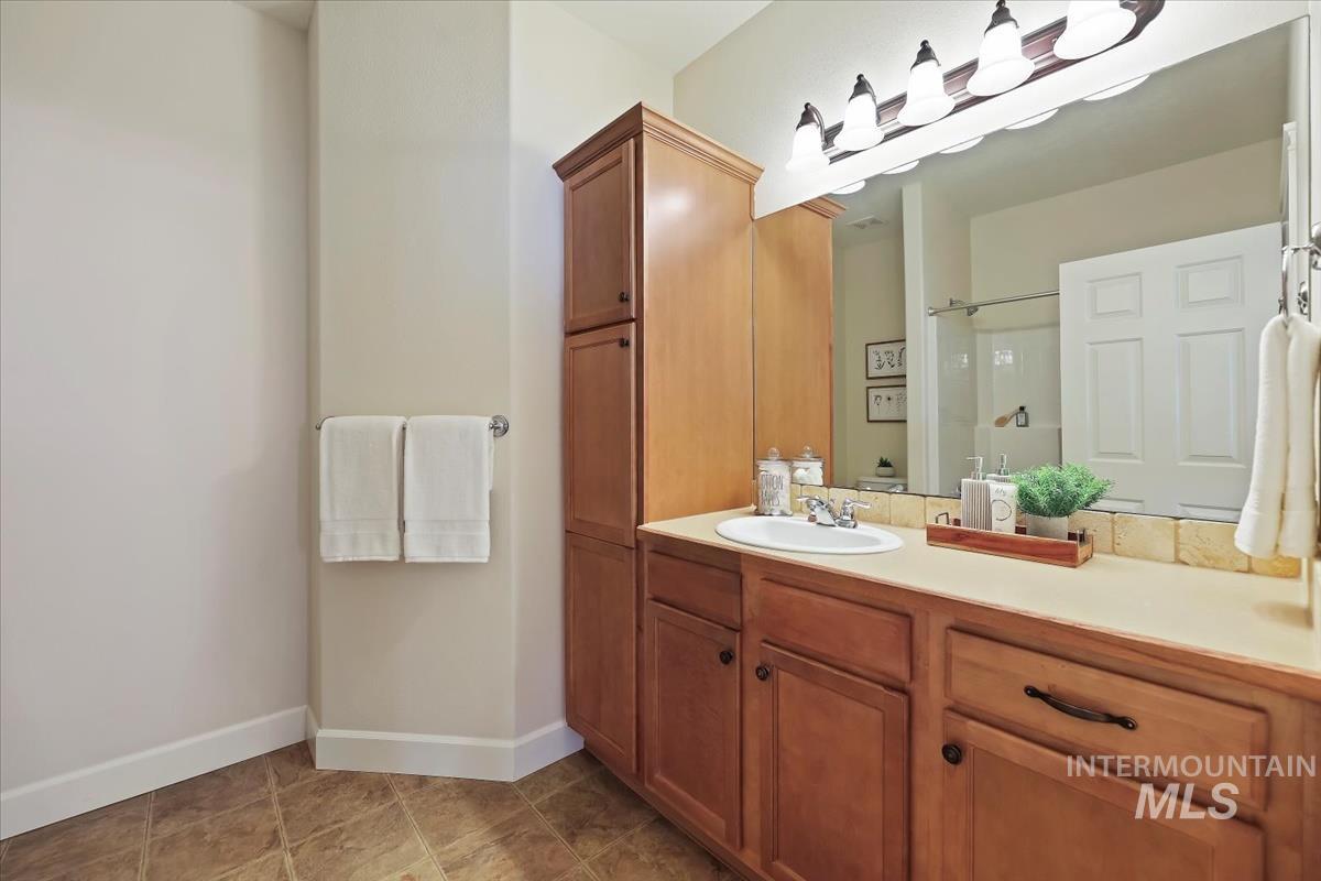 Full bath featuring vanity, a shower, and light tile patterned floors