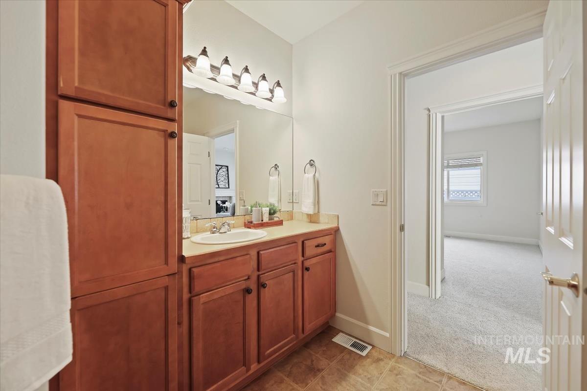 Bathroom featuring vanity, light carpet, and light tile patterned floors