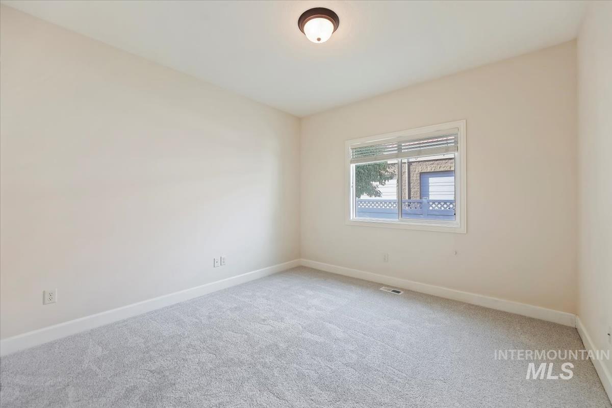 Carpeted spare room with baseboards