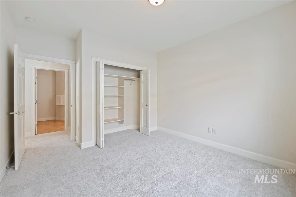Unfurnished bedroom featuring light colored carpet and a closet
