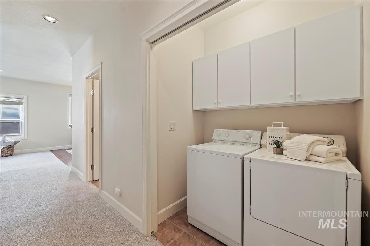 Washroom with light colored carpet, recessed lighting, separate washer and dryer, and cabinet space