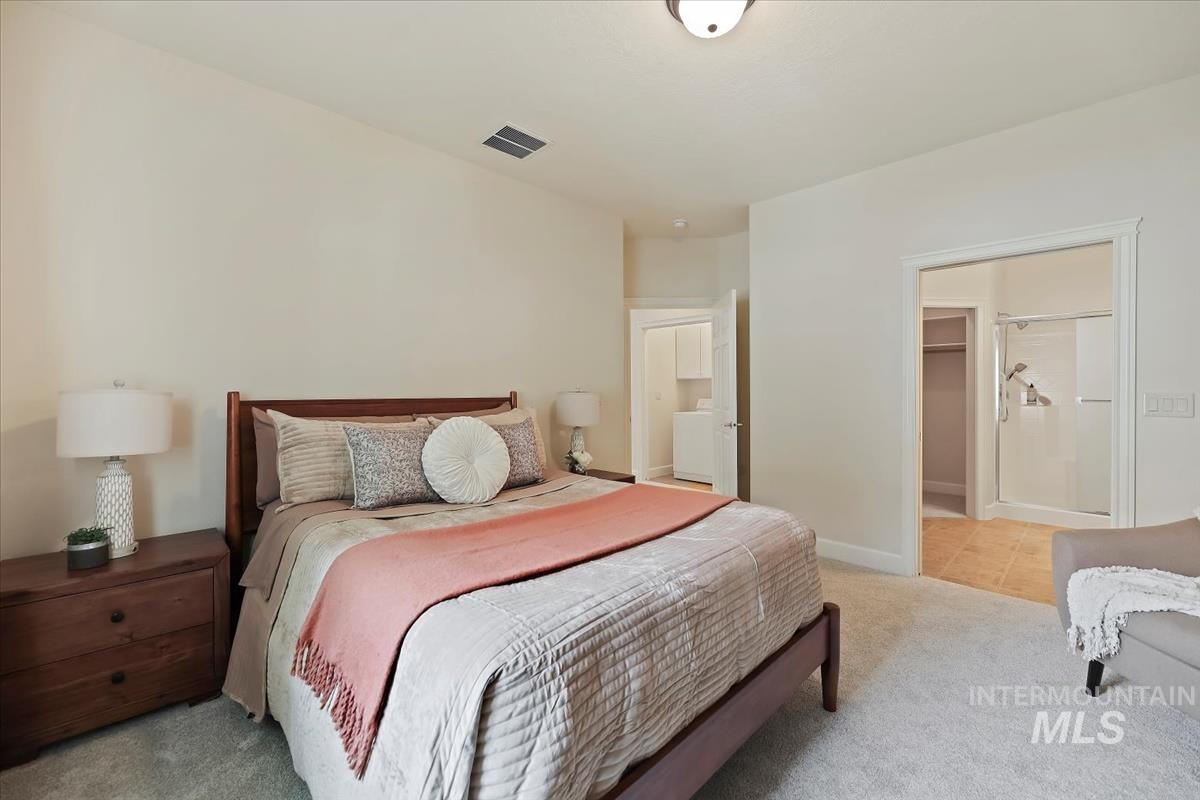 Bedroom with light colored carpet and ensuite bath