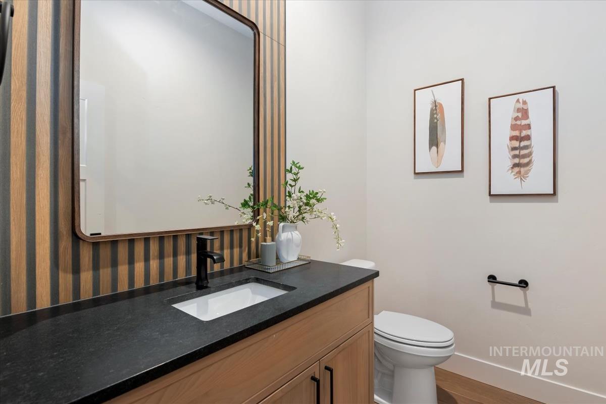Half bathroom featuring vanity and wood finished floors