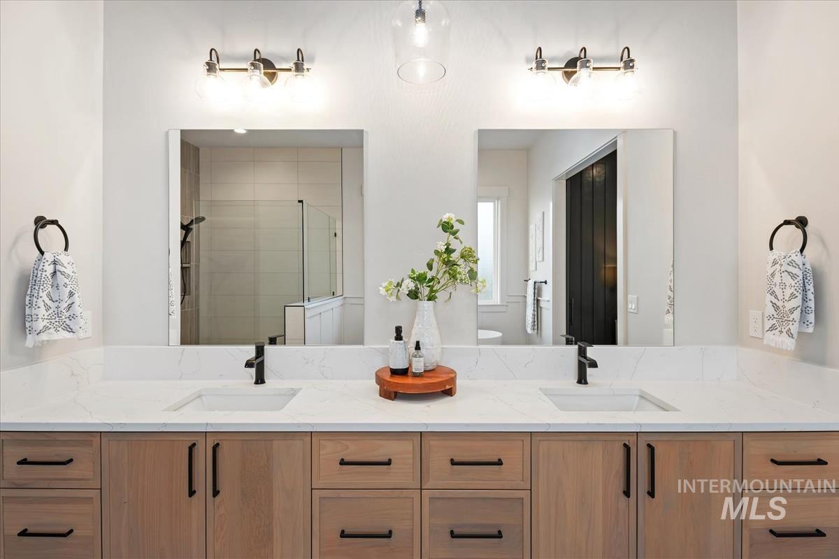Bathroom with double vanity and a stall shower