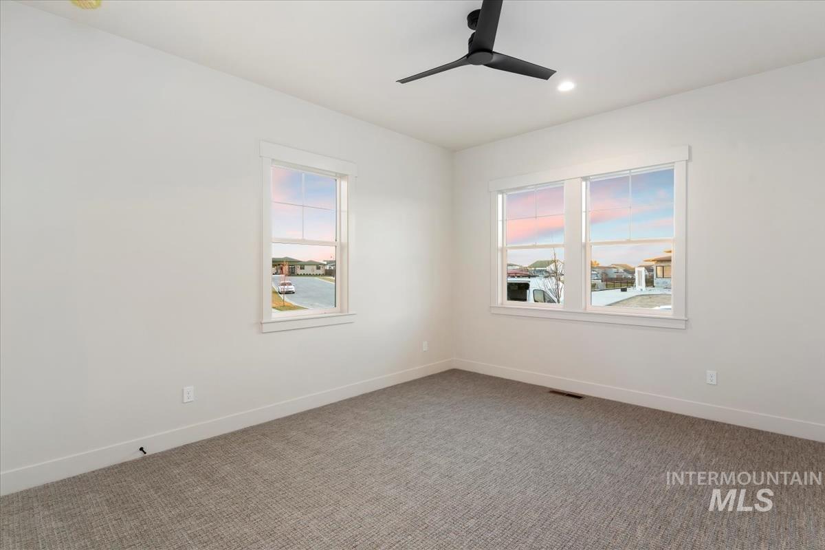 Empty room with healthy amount of natural light, carpet floors, recessed lighting, and a ceiling fan