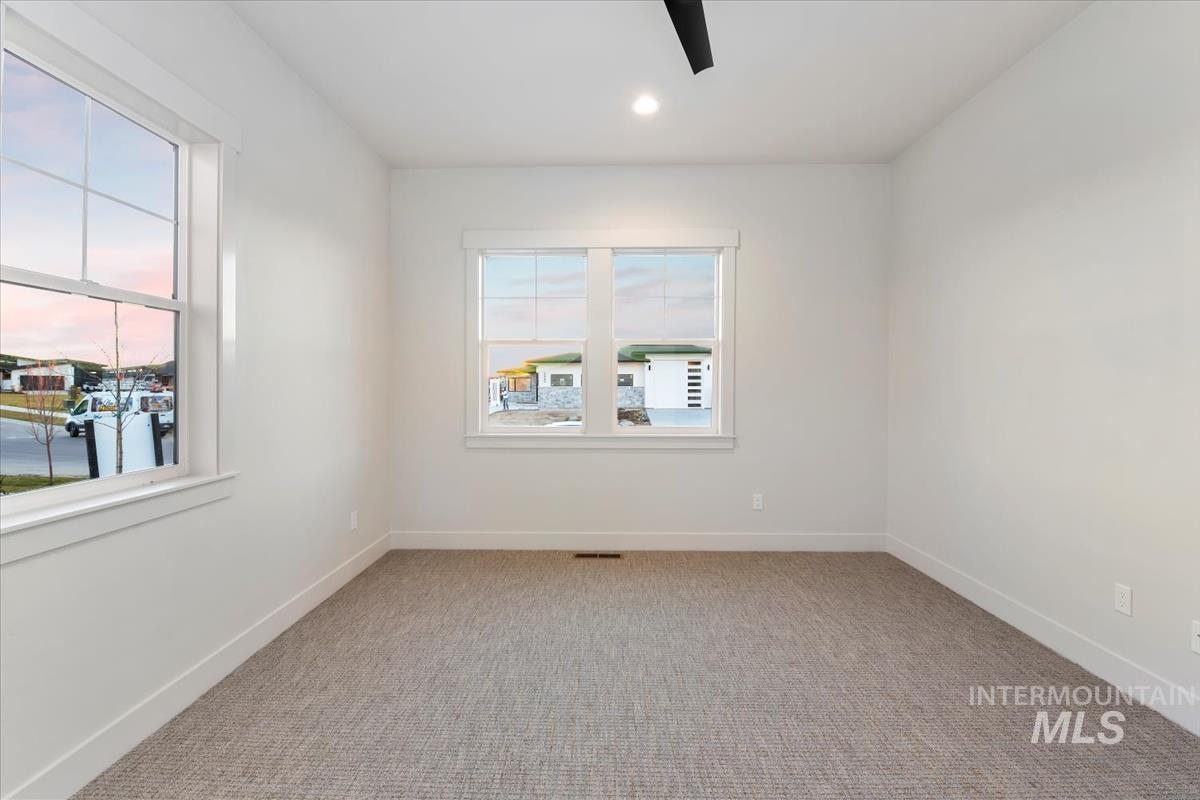 Spare room with light colored carpet, healthy amount of natural light, recessed lighting, and ceiling fan