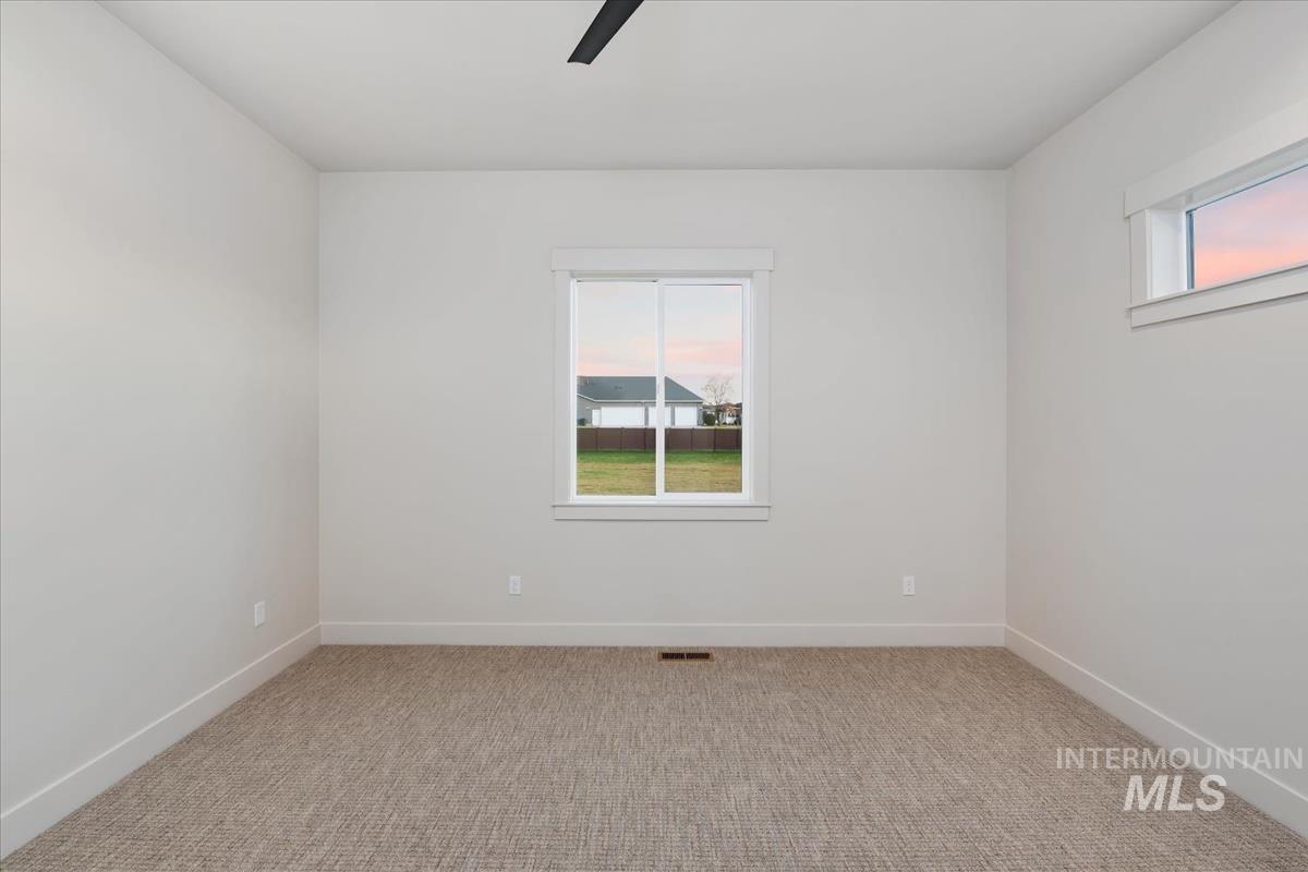 Unfurnished room featuring plenty of natural light, light carpet, and ceiling fan