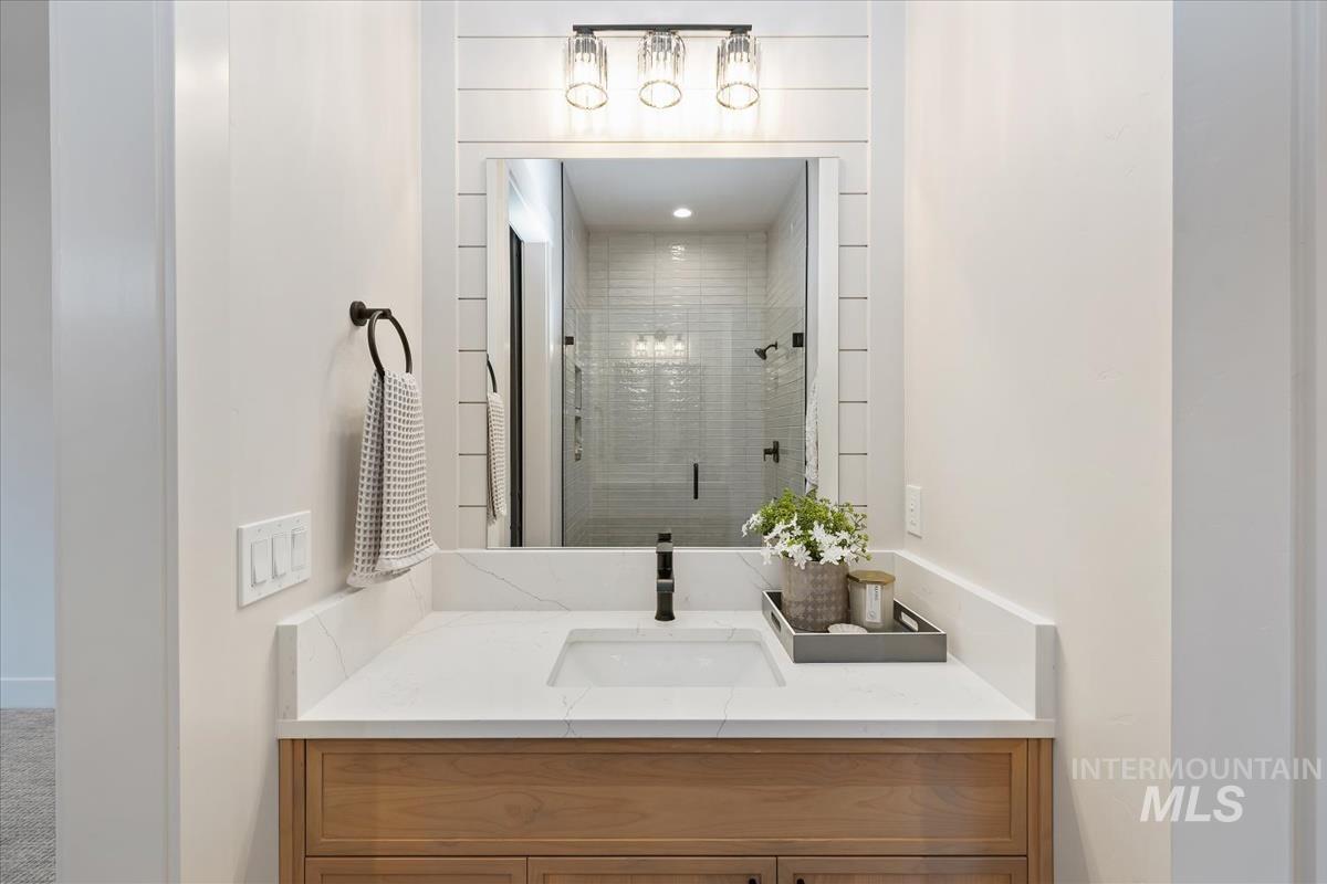 Full bath featuring a stall shower and vanity