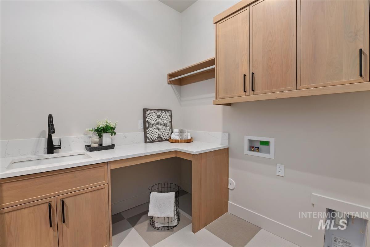 Laundry room with cabinet space, light flooring, and washer hookup