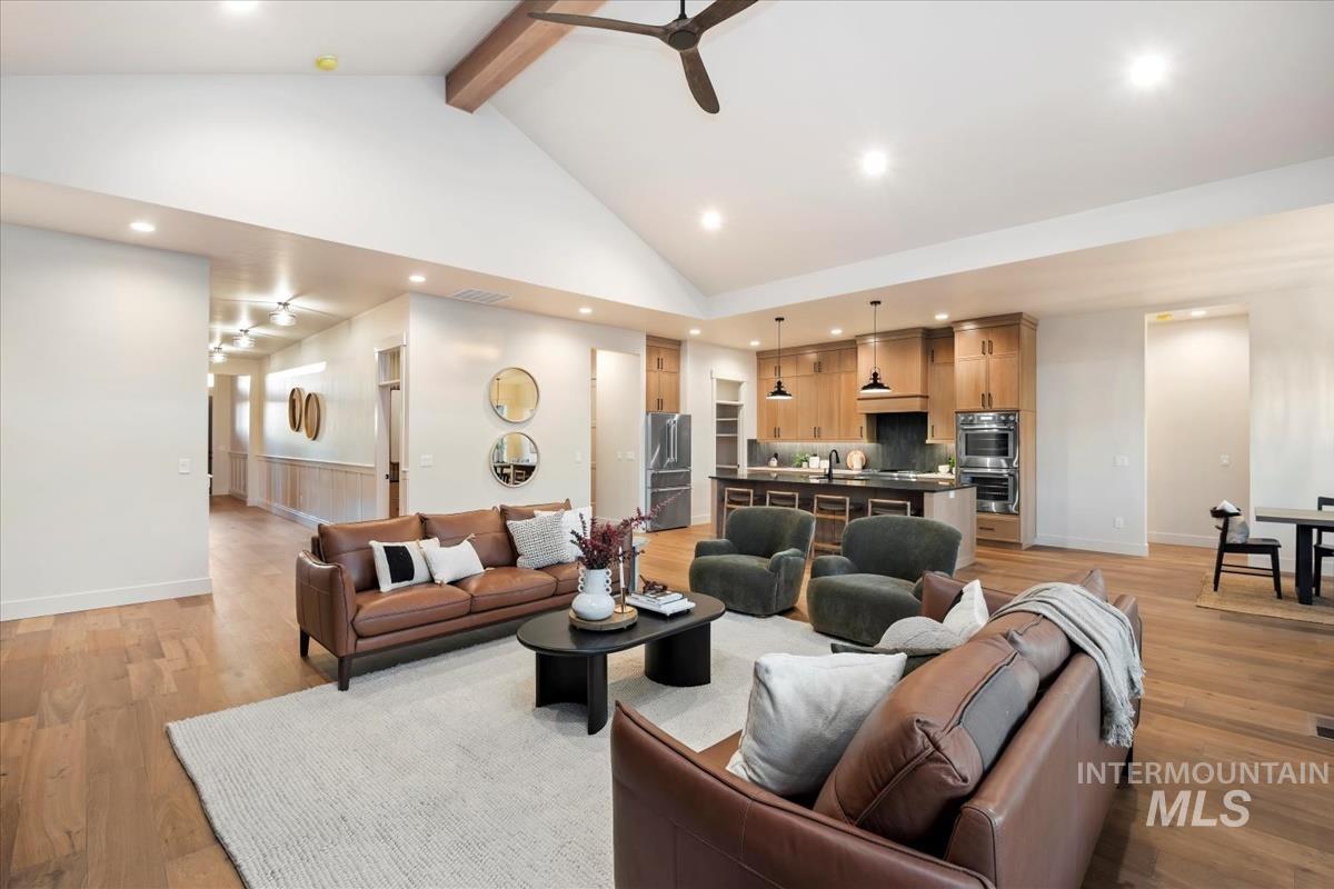 Living room featuring a ceiling fan, high vaulted ceiling, light wood-type flooring, beamed ceiling, and recessed lighting