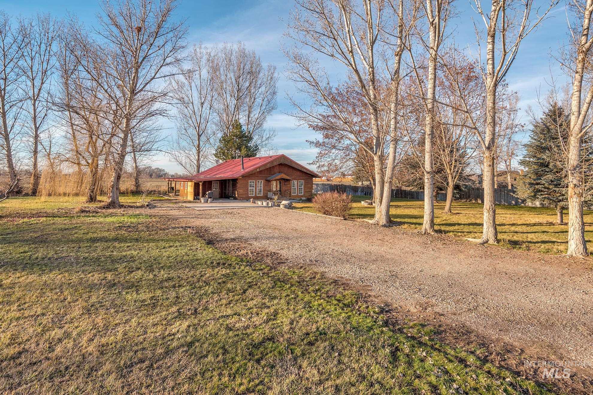 View of front of property featuring a metal roof, a front lawn, and dirt driveway