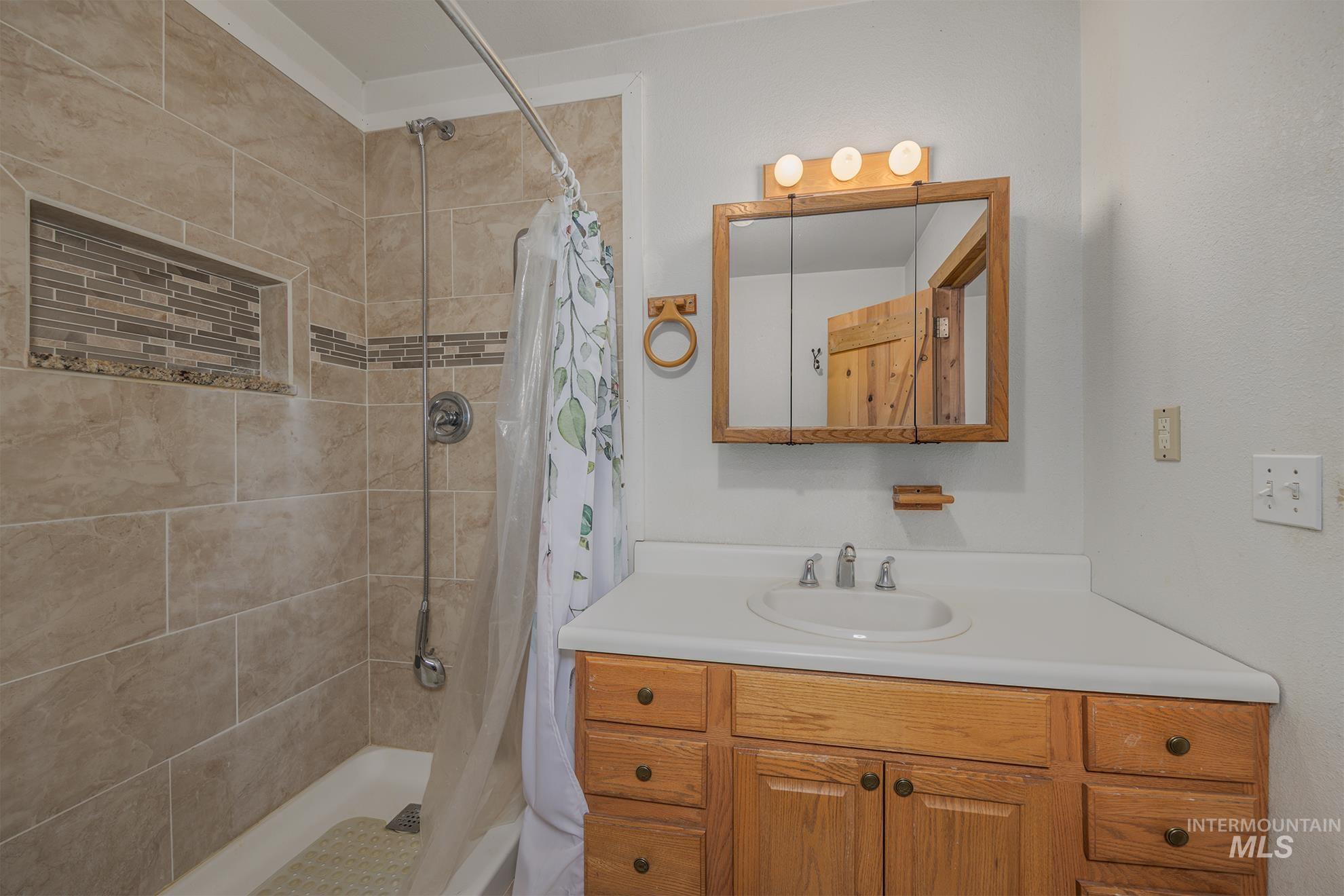 Bathroom featuring vanity and a stall shower