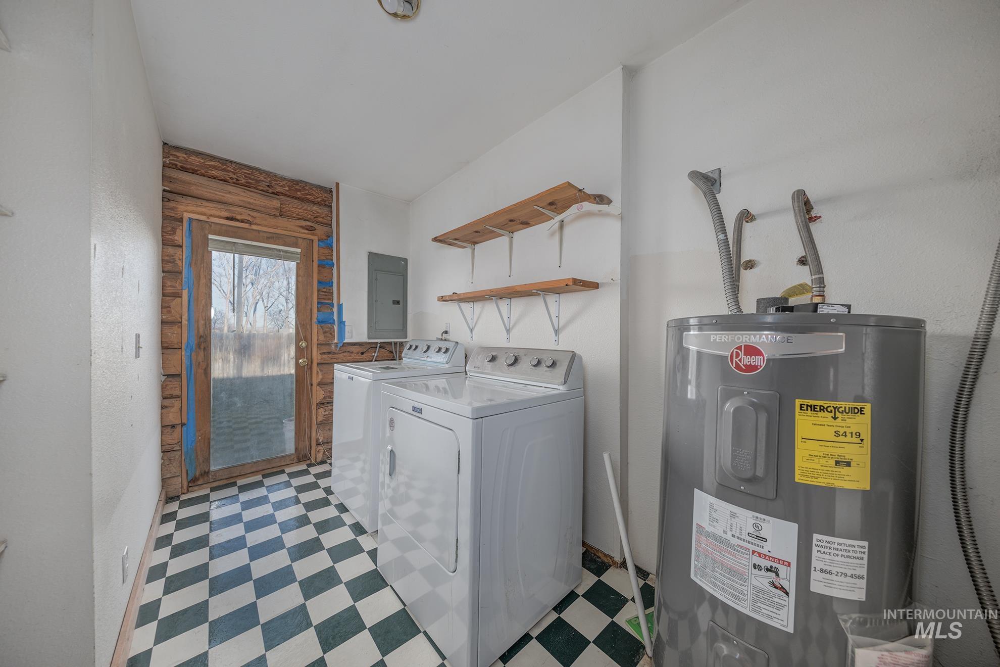 Laundry room featuring light flooring, water heater, washing machine and dryer, and electric panel
