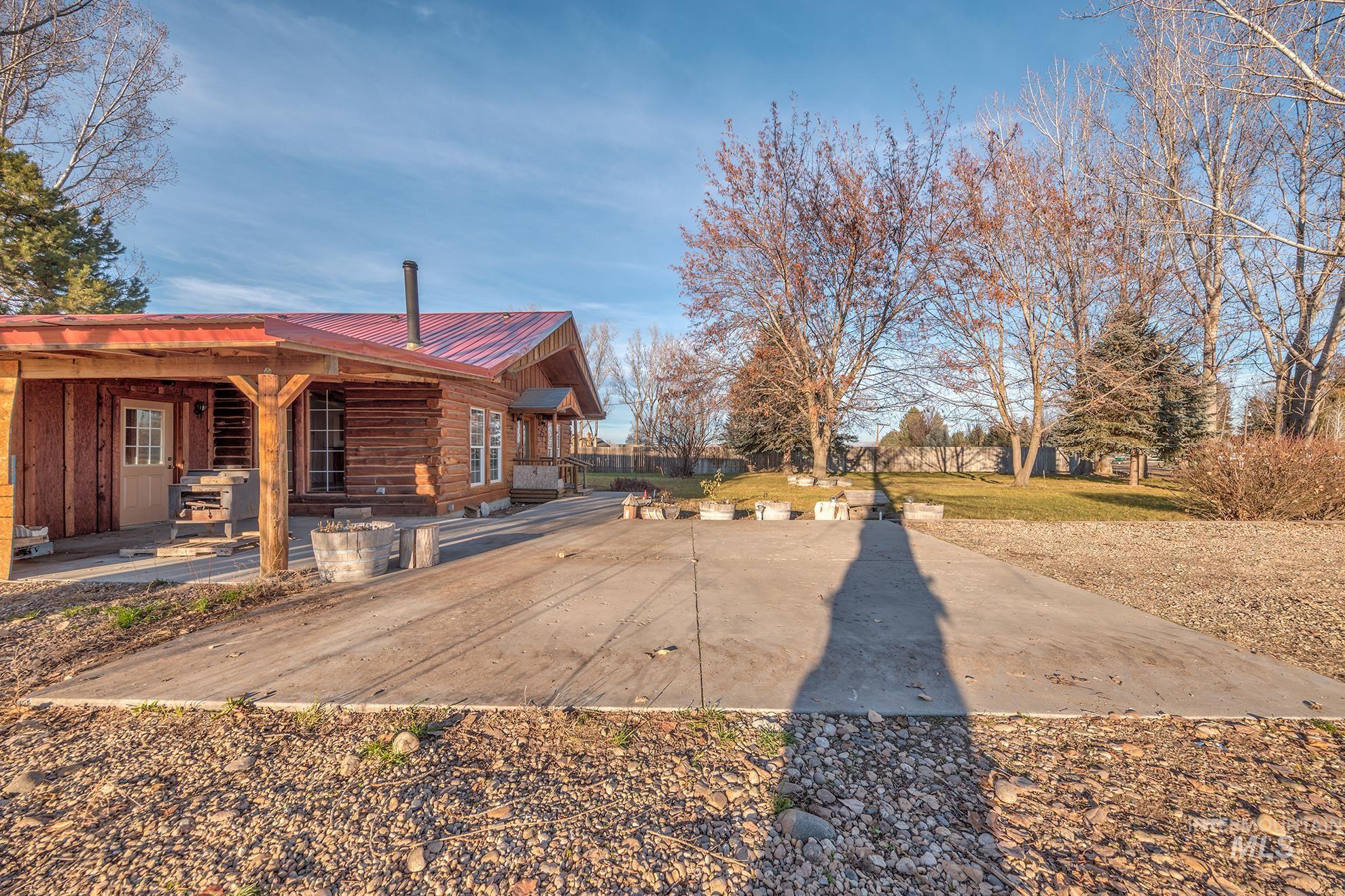 View of side of home with a patio, a metal roof, a lawn, and log siding