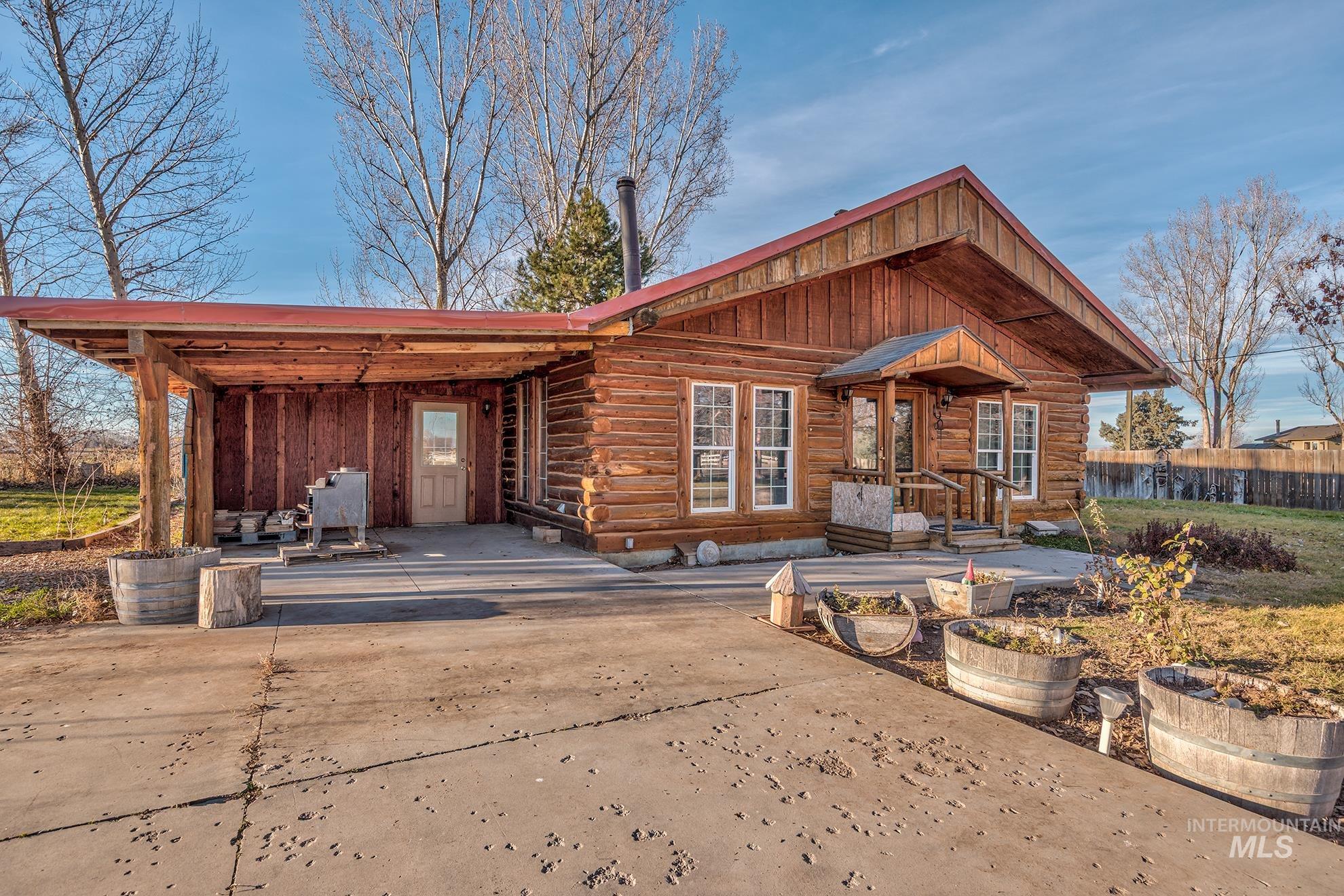 Rear view of house with log exterior and a patio