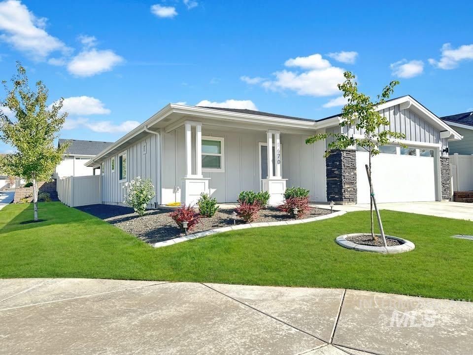 View of front of house with board and batten siding, a porch, an attached garage, and driveway