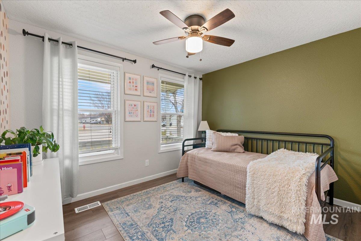 Bedroom featuring wood finished floors, a ceiling fan, and a textured ceiling