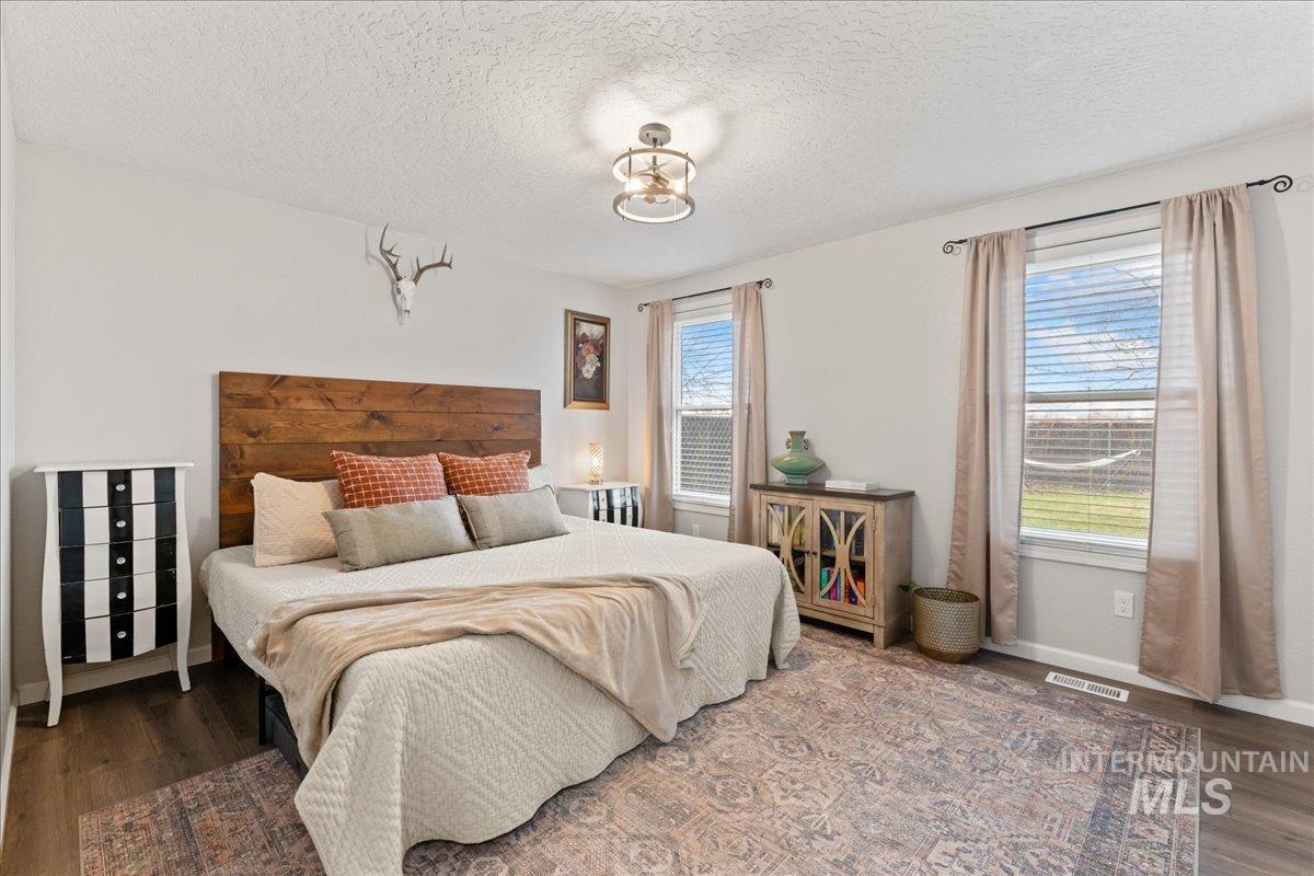 Bedroom with wood finished floors and a textured ceiling