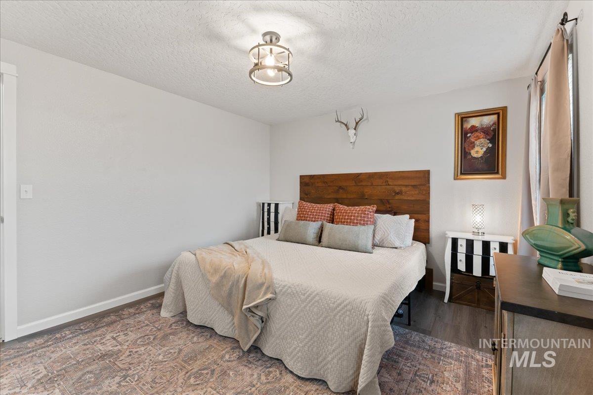 Bedroom featuring a textured ceiling and dark wood-style floors