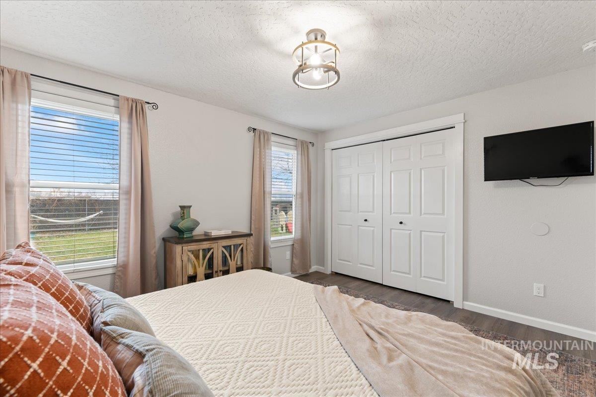 Bedroom featuring a textured ceiling, wood finished floors, and a closet