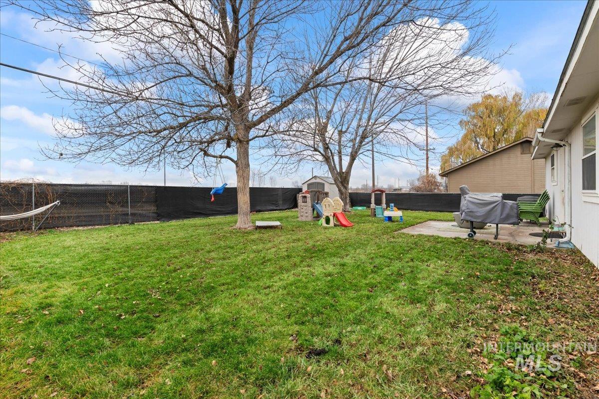 Fenced backyard with a playground and a patio