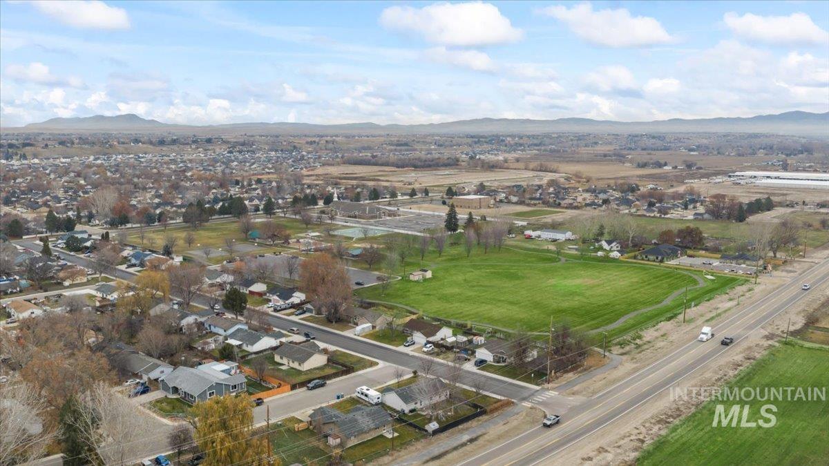 Aerial view of property and surrounding area with a mountain backdrop