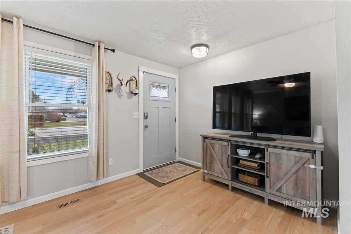 Entryway with a textured ceiling and light wood-type flooring