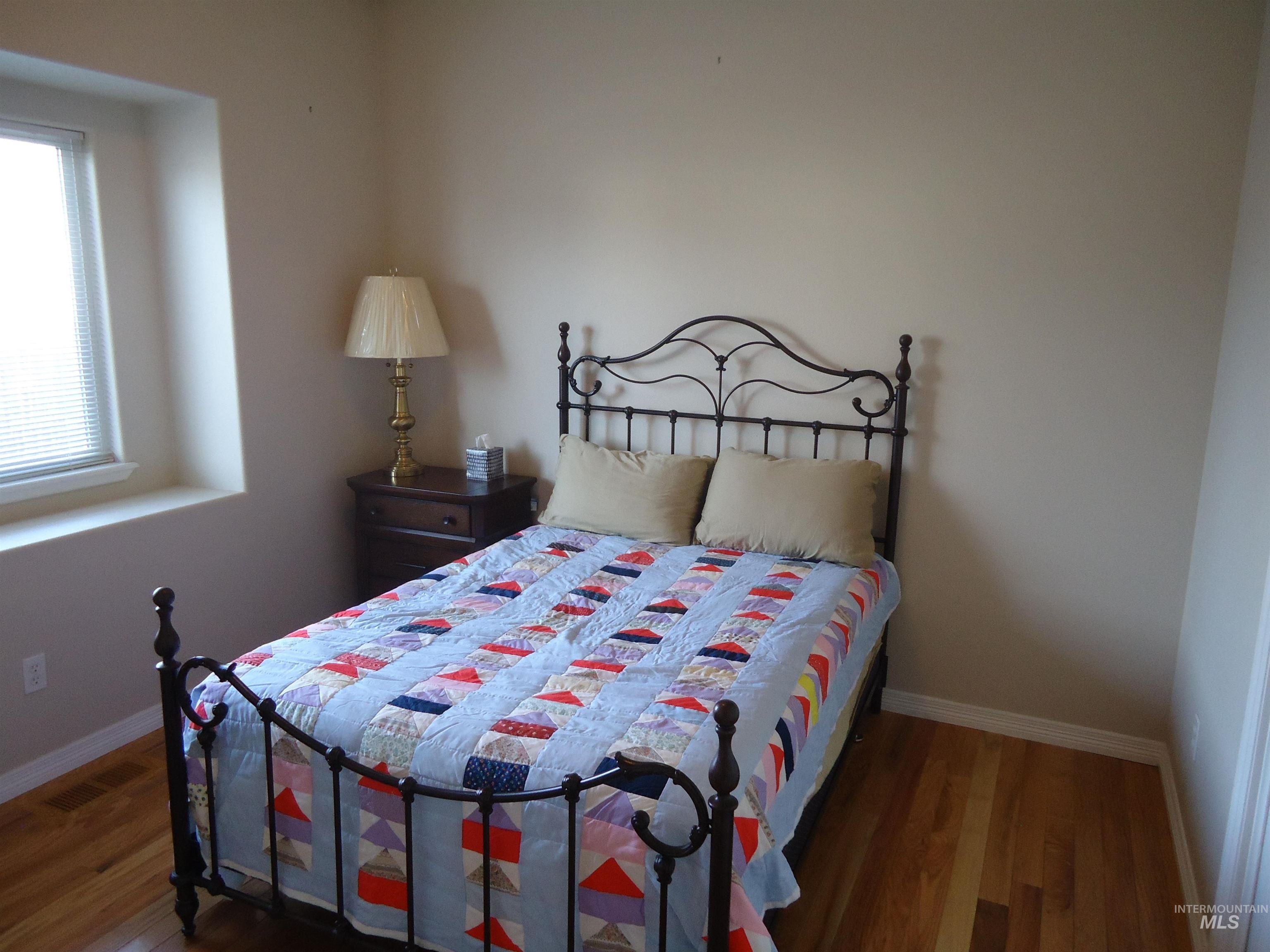 Bedroom featuring wood finished floors and baseboards