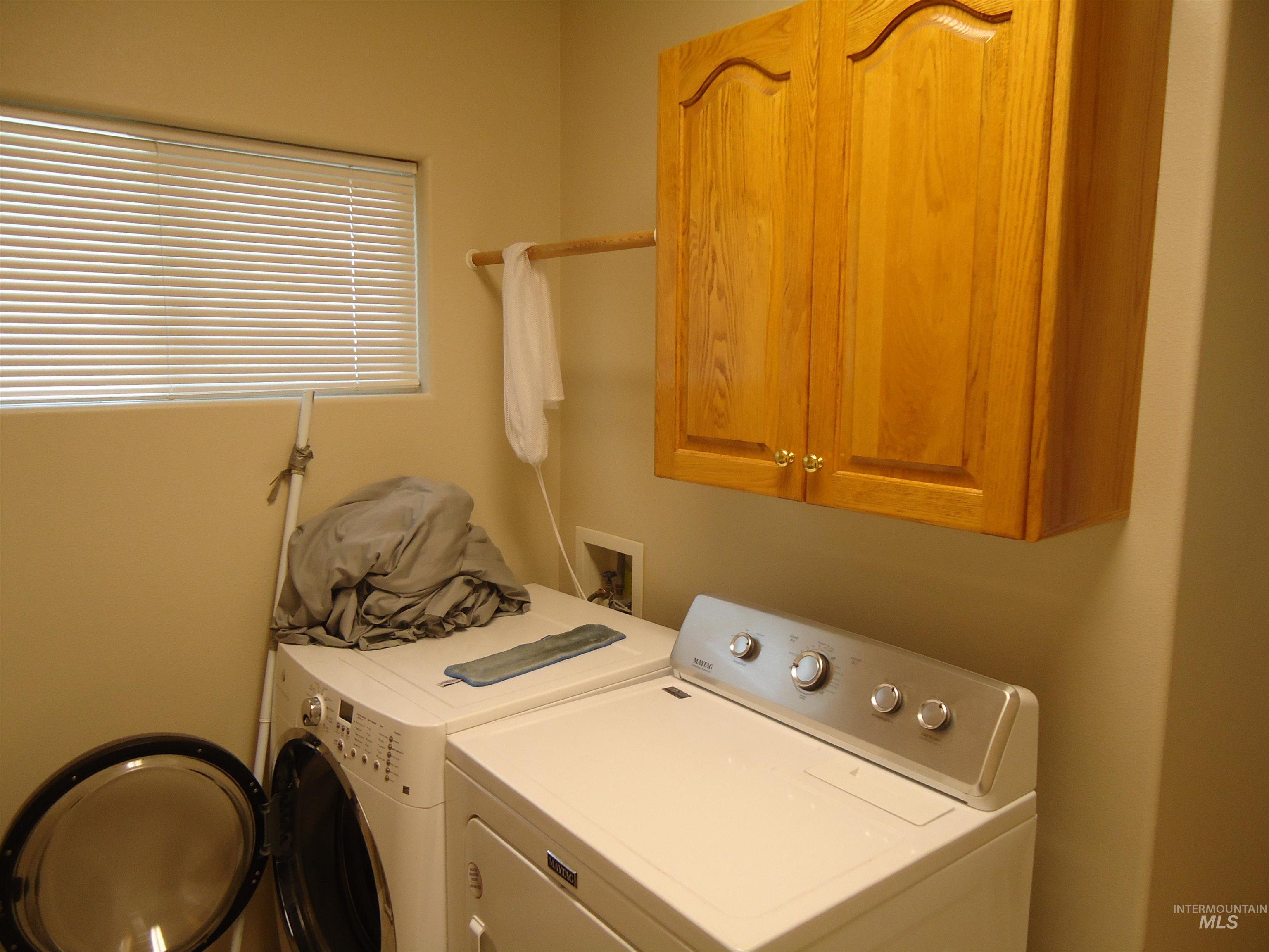 Washroom with washing machine and clothes dryer and cabinet space