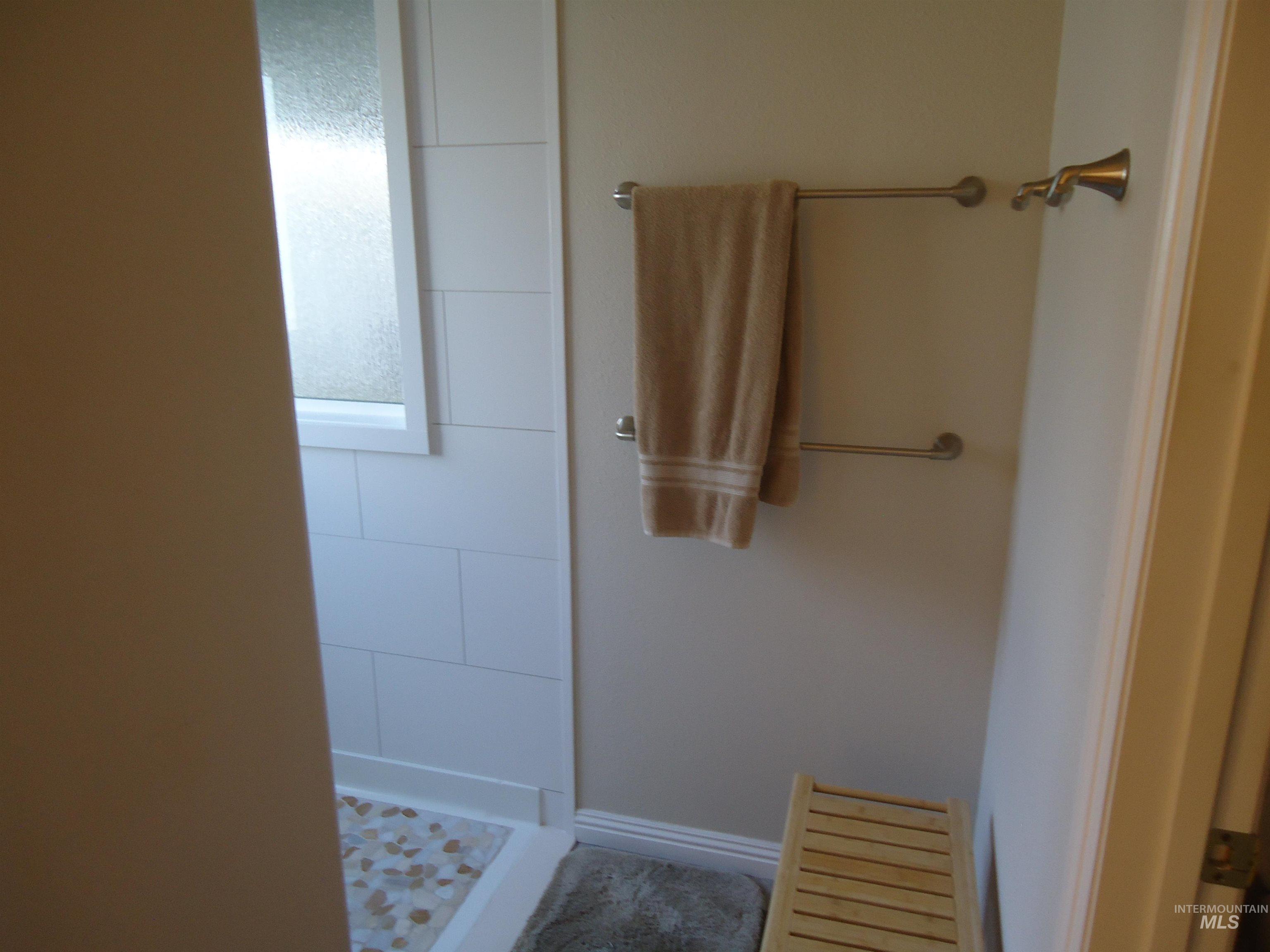 Full bath with a stall shower and baseboards