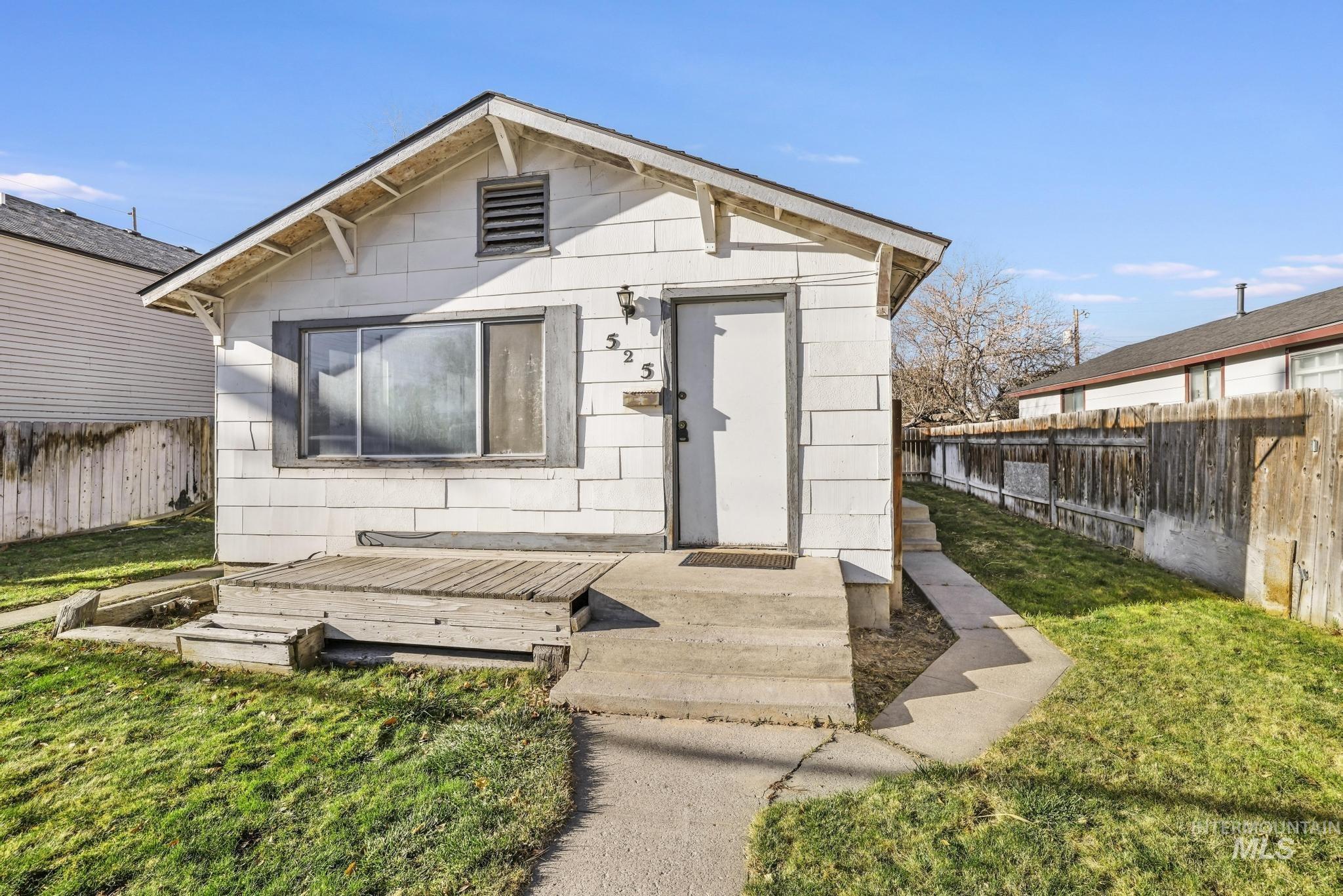 View of front facade with a fenced backyard and a deck