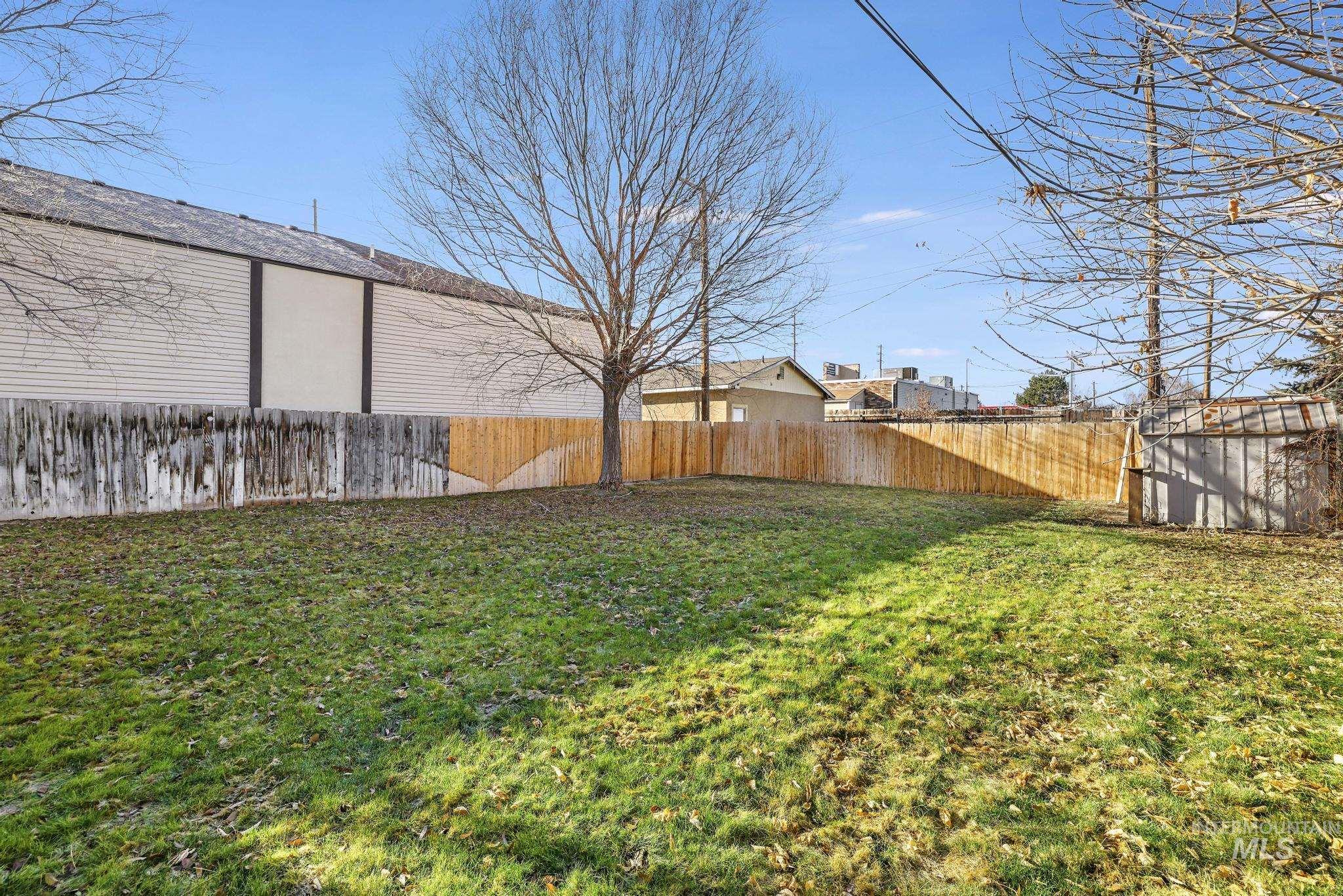 Fenced backyard featuring an outdoor structure