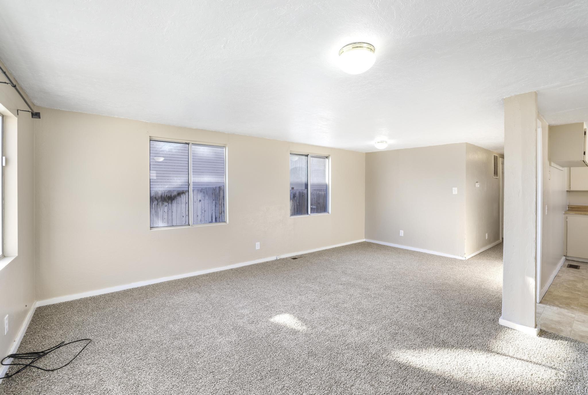 Carpeted empty room with baseboards